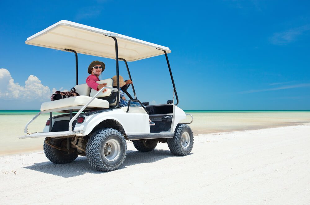 A man looks back at the camera on one of the many golf carts while on the beach in Destin, Florida.